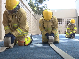 Fire Academy students rolling fire hoses