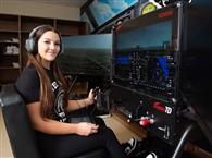 Student sitting in a flight simulator cockpit.